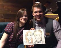 Таня и Влад улыбаясь держат свой рисунок от шаржиста Мишеля